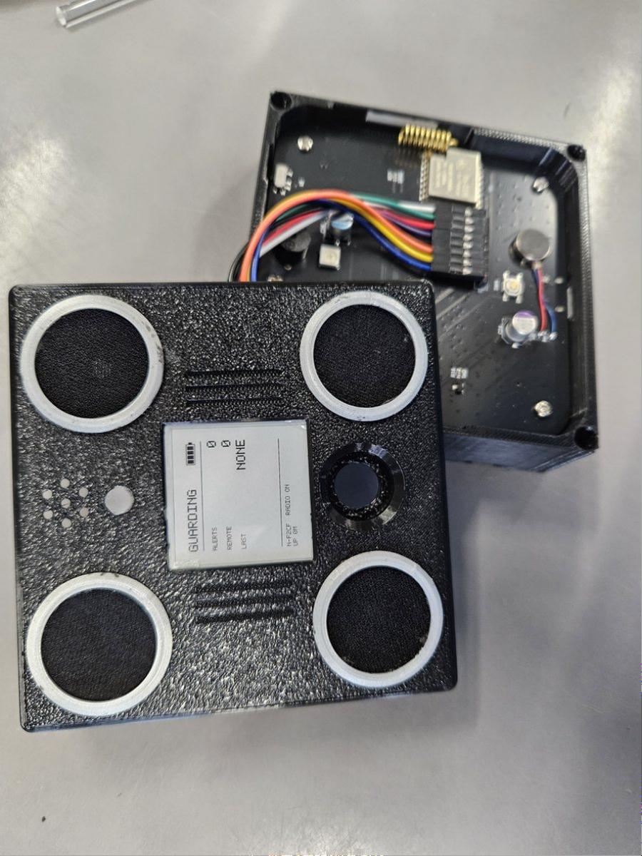 VolAnti front view beside its opened case showing the PCB and four microphones